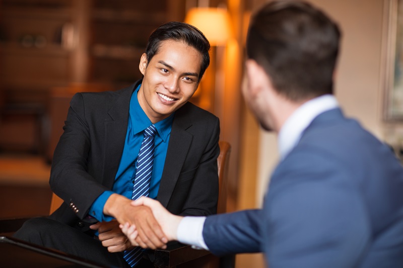 two smiling business partners shaking hands